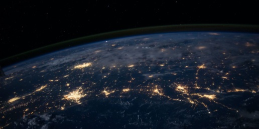 A shot of planet earth from space. Cities can be seen illuminated in clusters of light.