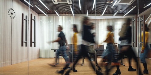 A busy office space with employees walking quickly